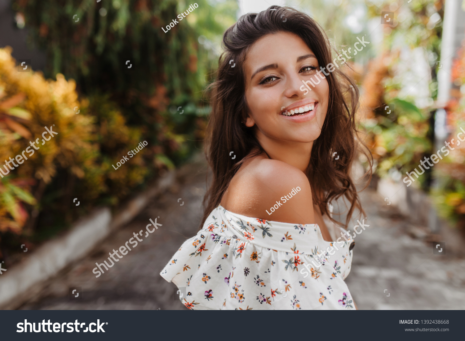 stock-photo-close-up-portrait-of-tanned-woman-on-rest-in-light-blouse-curly-dark-haired-girl-with-snow-white-1392438668.jpg